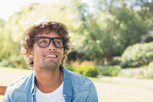 istock Hip young man sitting on park bench smiling 498553335