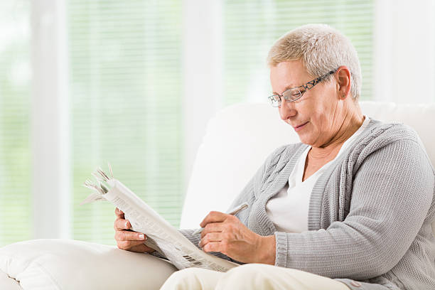 istock Senior woman reading newspapers 498553793