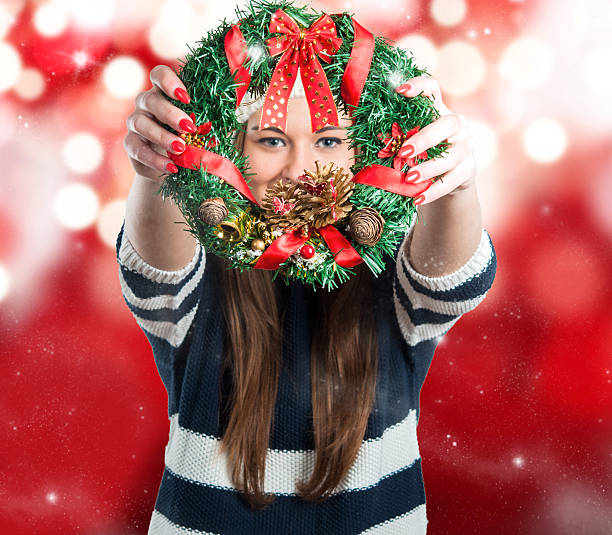 Pretty Young Girl Looking through Christmas Wreath.