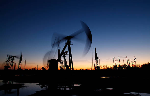 istock the evening of beam pumping unit in silhouette 498554838