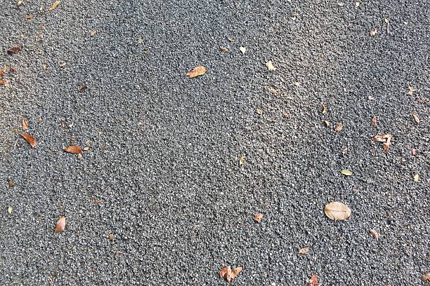 gray cement road background with little leaves stock photo