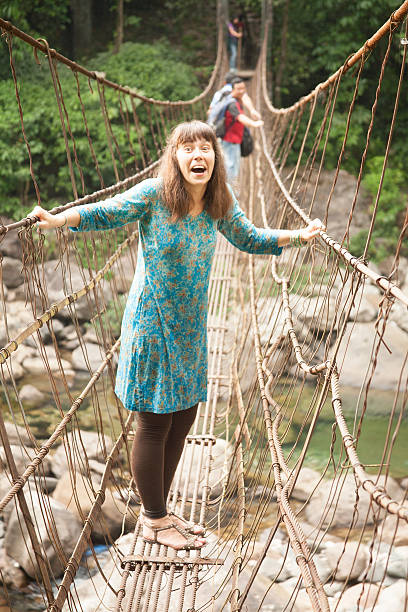 istock People walking on rustic cable, wire suspension bridge. 498555450