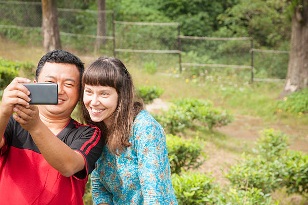 istock Asian, Russian couple take selfie on smart phone. Nature. 498556108