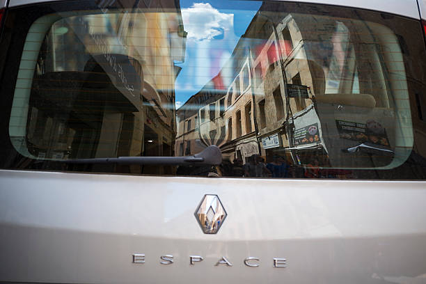 Aix-en-Provence, France - May 30, 2014: A street scene in Aix-en-Provence, reflected in the rear window of a parked Renault Espace. The Espace is a large multi-purpose-vehicle (MPV) from French car-maker Renault.