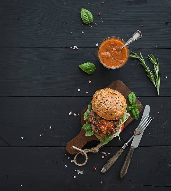 hambúrguer caseiras frescas no escuro tábua com molho picante de tomate - burger gourmet hamburger steak - fotografias e filmes do acervo