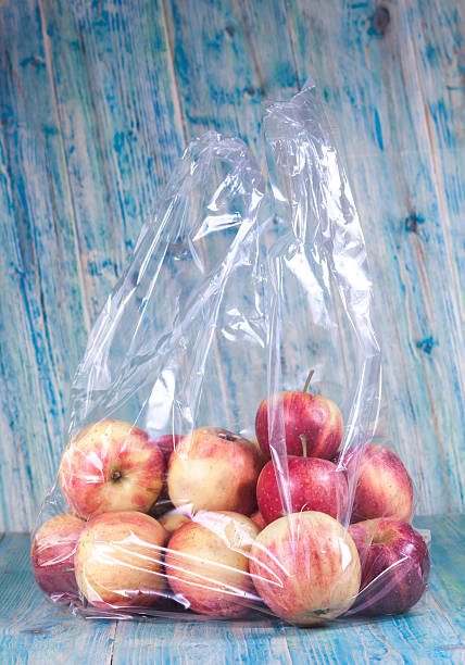 istock apple in plastic bag on wood 498559506