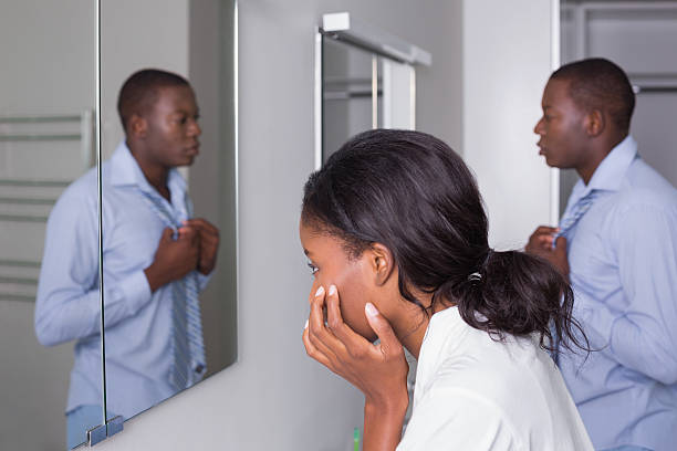 istock Couple looking in the bathroom mirror 498567325