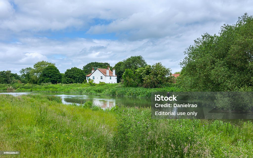 Man fishing on river Hull, Beverley, Yorkshire, UK. Beverley, UK - June 18, 2014: An unidentified man fishes on the river hull on a bright spring morining near Beverley, Yorkshire, UK. Adult Stock Photo