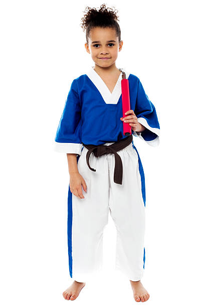 Smiling young karate girl with nunchucks
