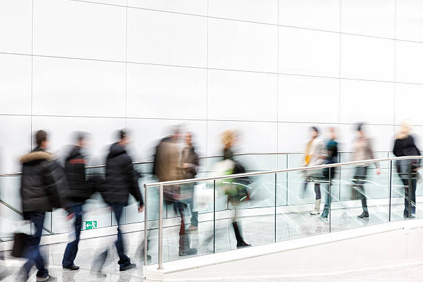 istock Crowd of Motion Blurred People Walking in Modern Hallway 498571141