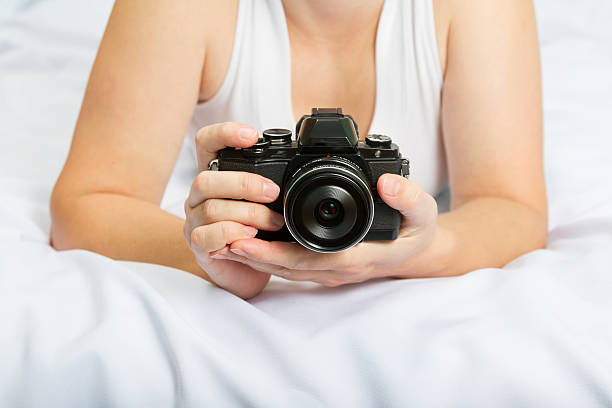 istock Young caucasian woman on the bed with the camera 498571208