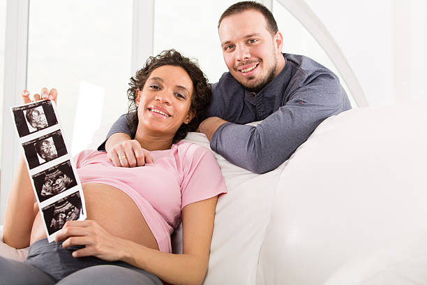 istock Pregnant couple showing baby sonogram 498571345