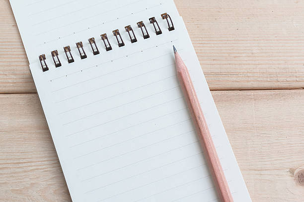 istock Open blank notepad on wood table background with brown pencil 498571812