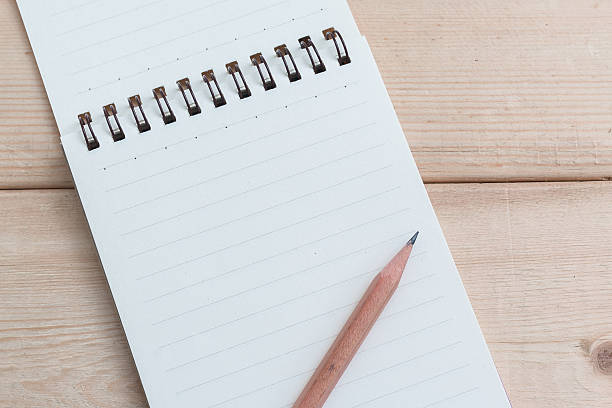 istock Open blank notepad on wood table background with brown pencil 498571862