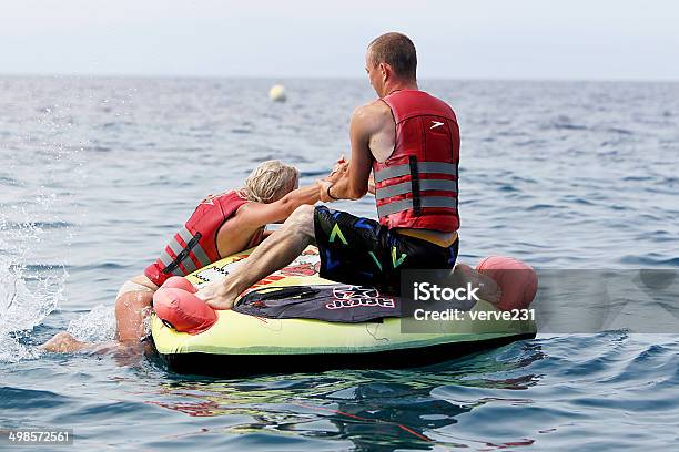 Unrecognized Man Helping Woman To Get On Water Inflatable Stock Photo - Download Image Now