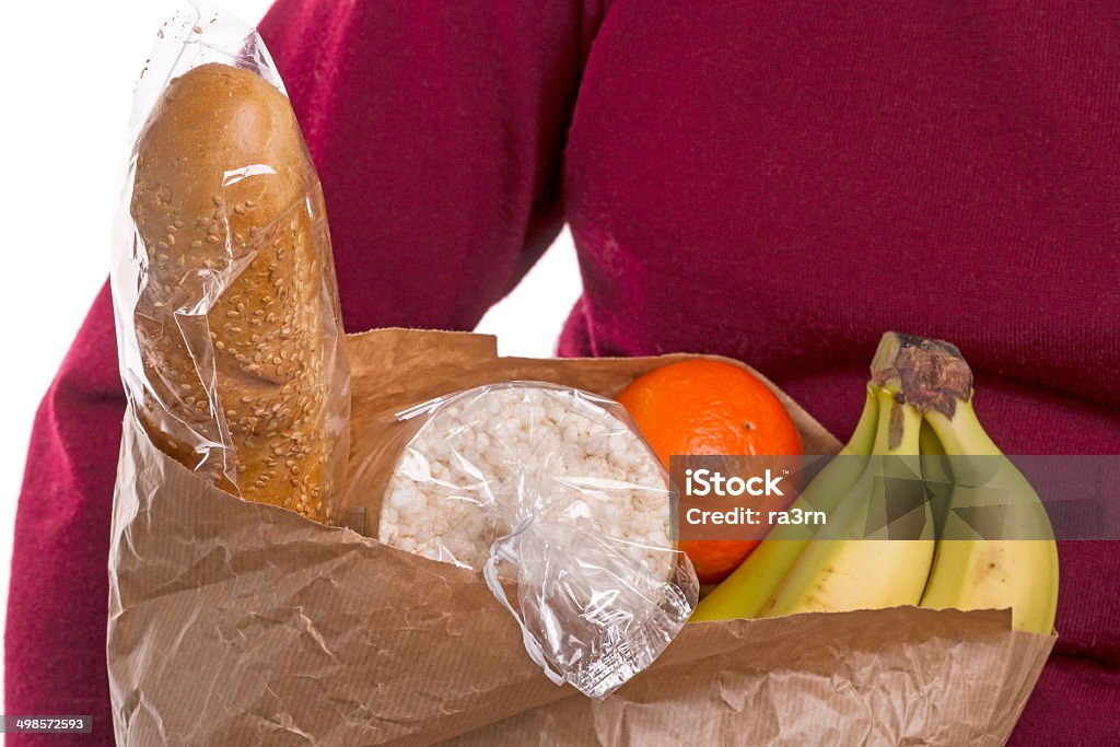 Woman Carrying Bag Of Groceries Woman and a paper bag with food on a white background Adult Stock Photo