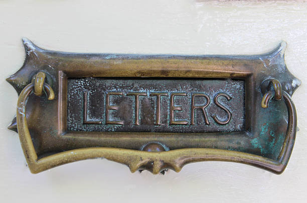 istock Image of ornate brass letter box on white front door 498576419