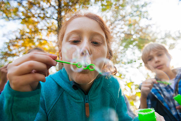 Friends blowing bubbles outdoors