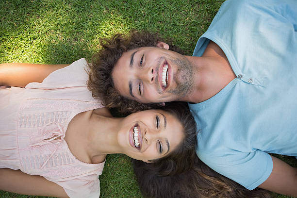 istock Young couple lying on grass smiling at camera 498579863
