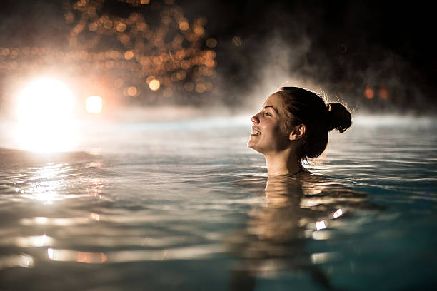 de invierno mujer feliz pasar una noche en la piscina climatizada. - hot spring fotografías e imágenes de stock
