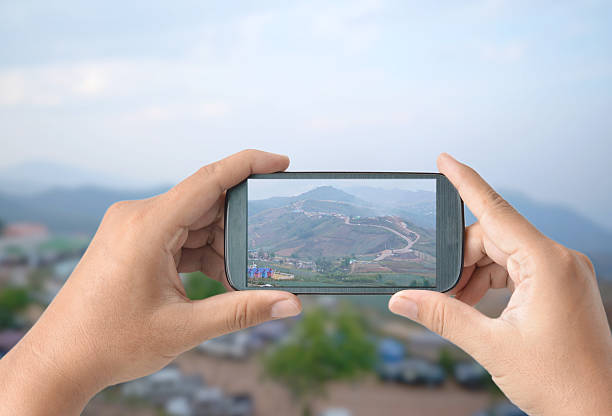 istock tourist taking photo with camera smart phone at Mountain road 498580232