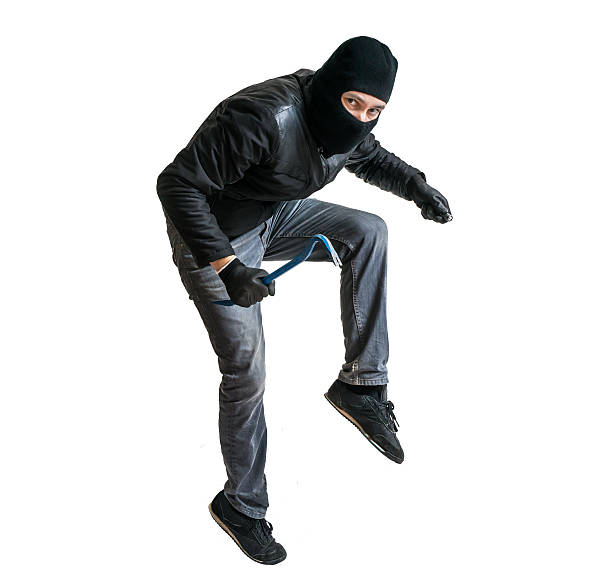 Robber in balaclava or burglar creeping on tiptoe. Isolated on white.