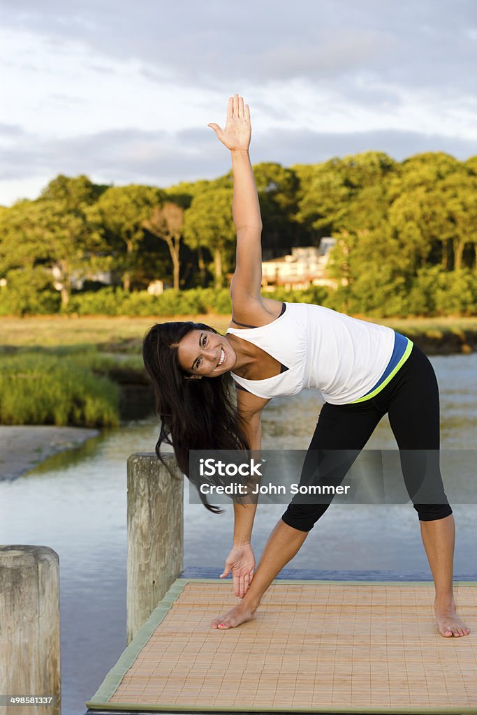 Woman doing yoga Smiling woman doing yoga outdoors  20-29 Years Stock Photo