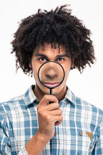 istock Afro american man holding magnifying glass 498582178