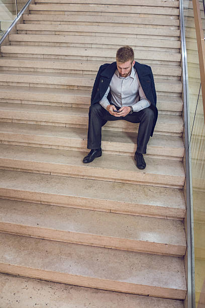 istock Relaxed businessman using mobile phone on the stairs. 498583154