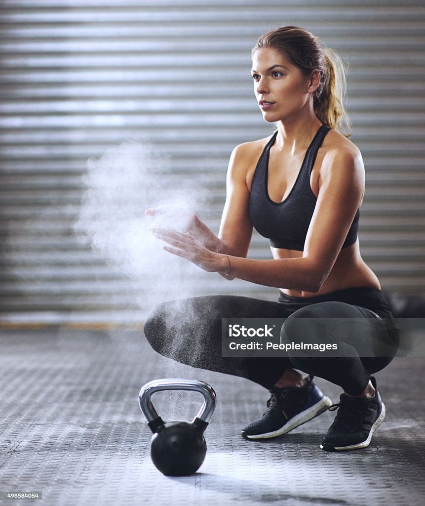 Ready to start lifting Shot of a young woman coating her hands with sports chalk before a kettle bell workouthttp://195.154.178.81/DATA/i_collage/pi/shoots/806022.jpg Women Stock Photo