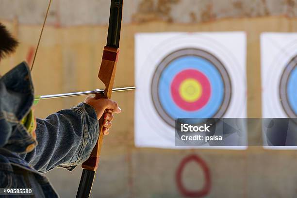 Archer Ponga El Tiro Con Arco En El Objetivo Foto de stock y más banco de imágenes de Tiro con arco - Tiro con arco, Interior, Arco - Deporte