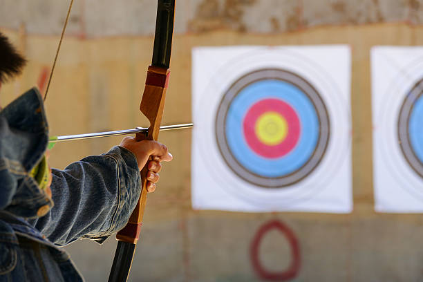 archer is aiming the archery at the target archer is aiming the arrow of the bow at the target archery bow stock pictures, royalty-free photos & images