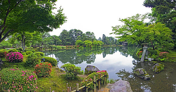 japanese garden with stone lantern and big mossy rocks stock photo