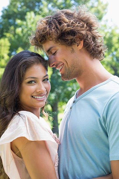 istock Cute young couple embracing in the park 498596365