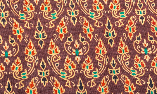An exotic colorful floral pattern weaved fabric as textural background.