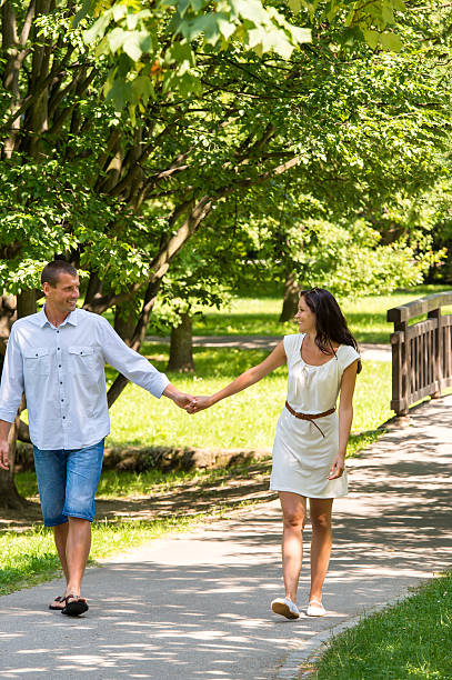 istock Couple in love holding hands walking park 498599499
