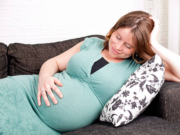 istock Pregnant young woman resting on the couch 498599683