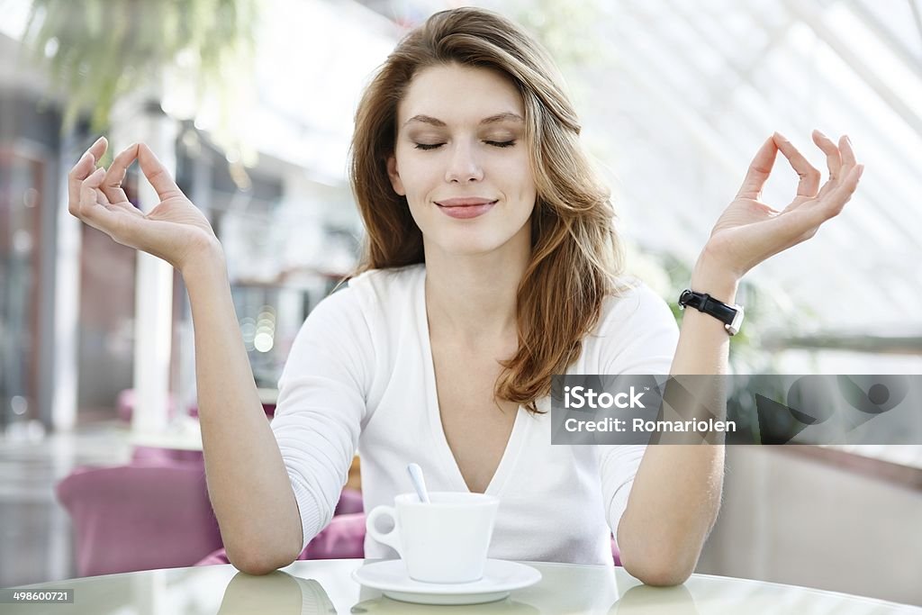 Meditation photo of beautiful woman sitting in a coffee house Adult Stock Photo