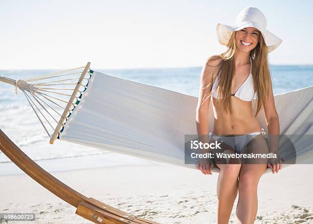 Bonita Rubia Usando Y Sunhat Bikini Sentada En Una Hamaca Foto de stock y más banco de imágenes de Adulto