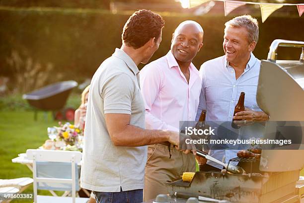 Foto de Macho Maduro Amigos Desfrutando De Um Churrasco Ao Ar Livre No Verão e mais fotos de stock de Amizade