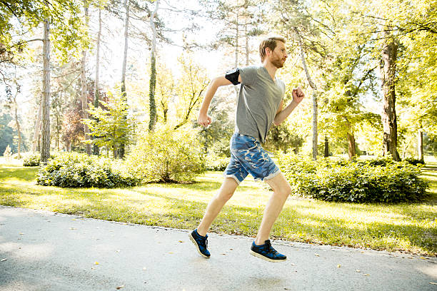 istock Young man running in the autumn park 498606418