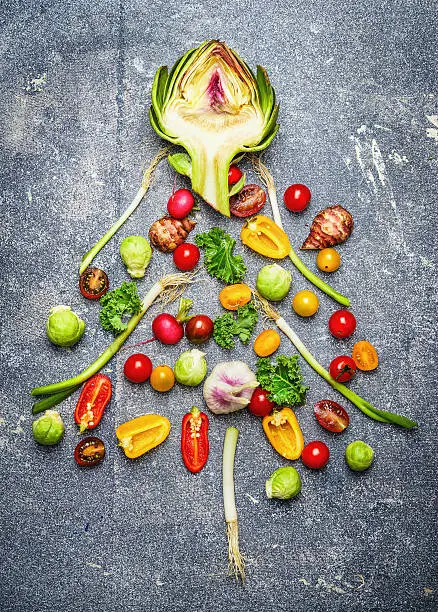 Photo of Christmas tree made ââof fresh vegetables on gray rustic bac