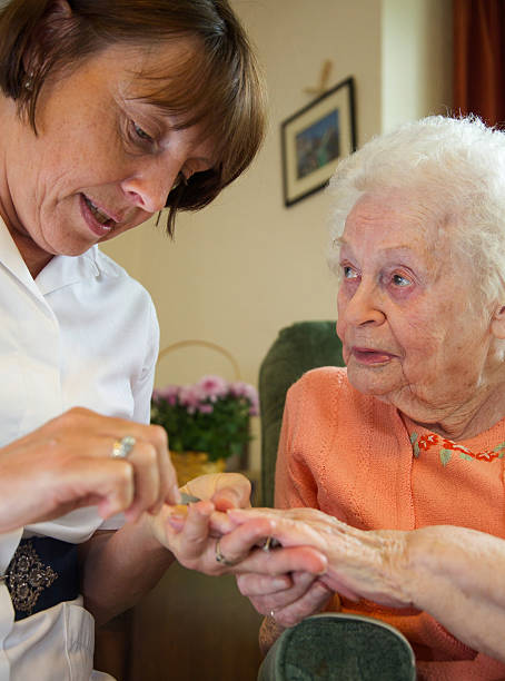 istock Care worker nurse caring for an elderly woman's nails 498609493