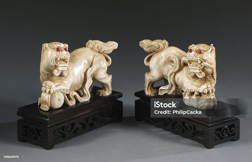 Pair Chinese Ivory Foo Lions Pair of antique Chinese ivory foo lions on wood plinths, circa 1900, unsigned.  On a gradient background. Carving - Craft Product Stock Photo
