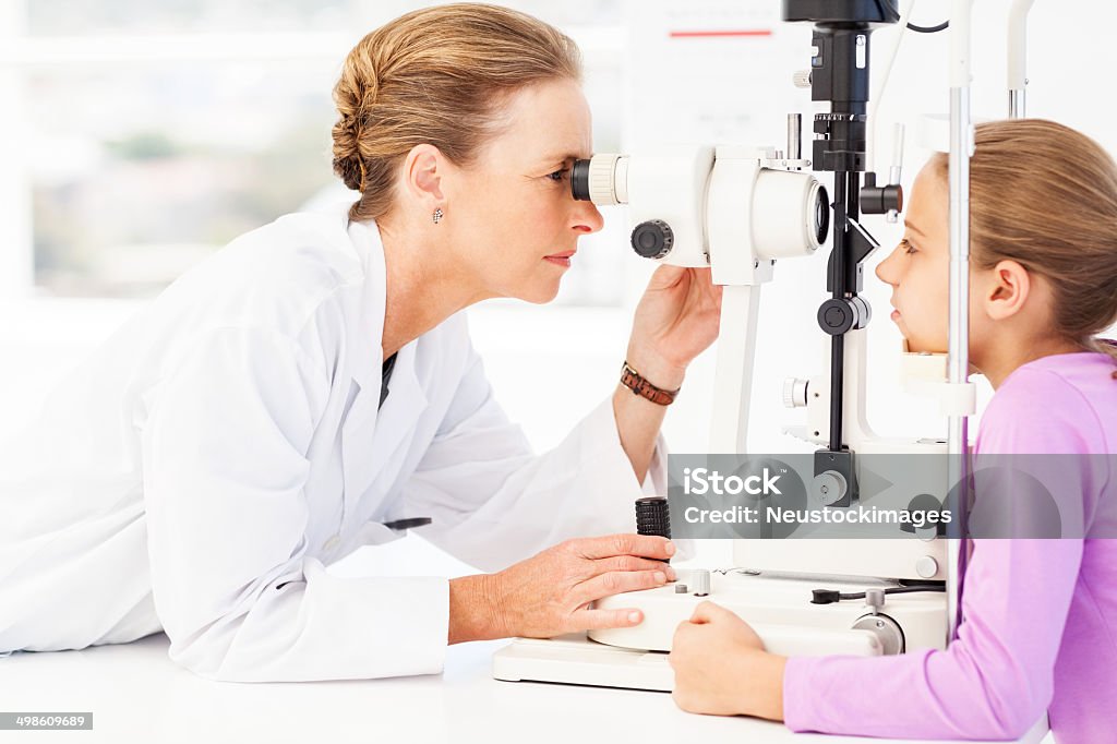 Augenoptiker untersuchen Mädchen Augen mit Schlitz Lampe - Lizenzfrei Ophthalmologe Stock-Foto
