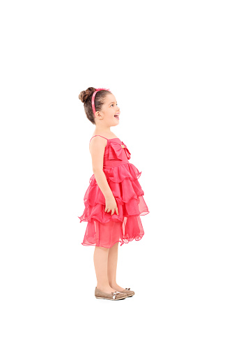 Profile shot of a cute kid in fancy dress looking up isolated on white background