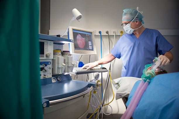 Anesthetist in operating theatre Anesthetist with patient , the patient is the one lying down , and the anaesthetist is the one standing up . oxygen monitor stock pictures, royalty-free photos & images