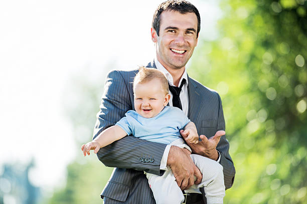 istock Businessman holding baby boy. 498609973