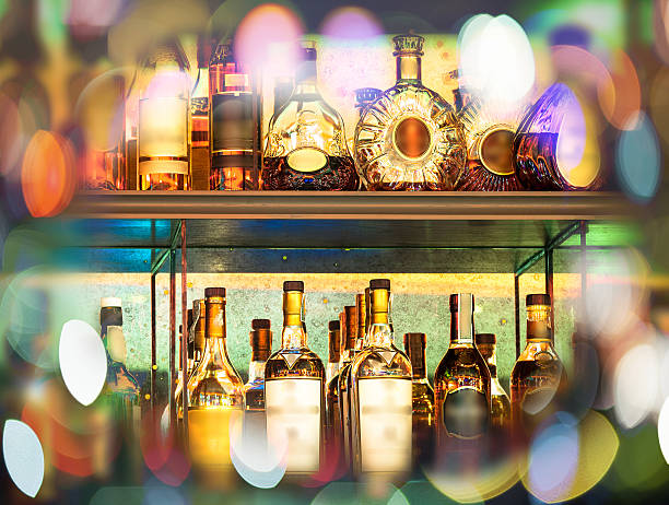 conjunto de garrafas de bebidas alcoólicas na parede com bokeh (desfoque de fundo) - beer wine drink collection - fotografias e filmes do acervo