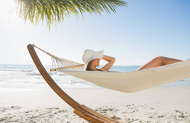 istock Woman wearing sunhat and bikini relaxing on hammock 498611427